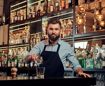 Foto van een barman die een drankje inschenkt